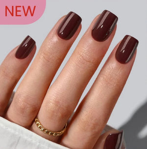 Hand with dark brown nail polish on a light gray background